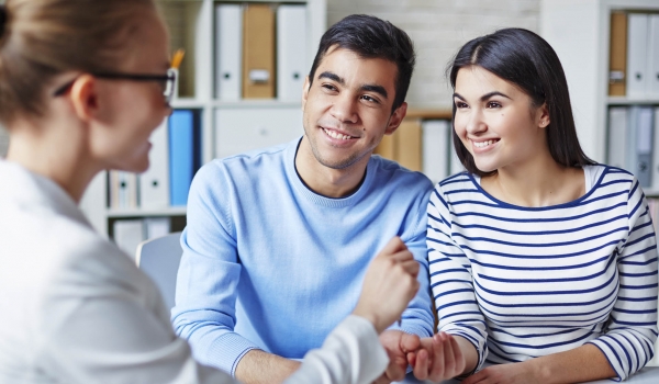 Happy Young Couple Making Deal With Realtor